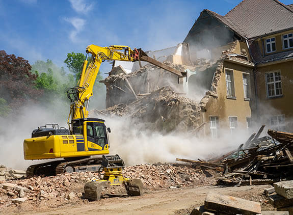 a construction vehicle with a crane in front of a building