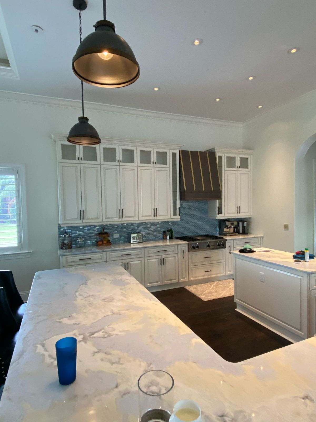 a kitchen with white cabinets and a marble countertop