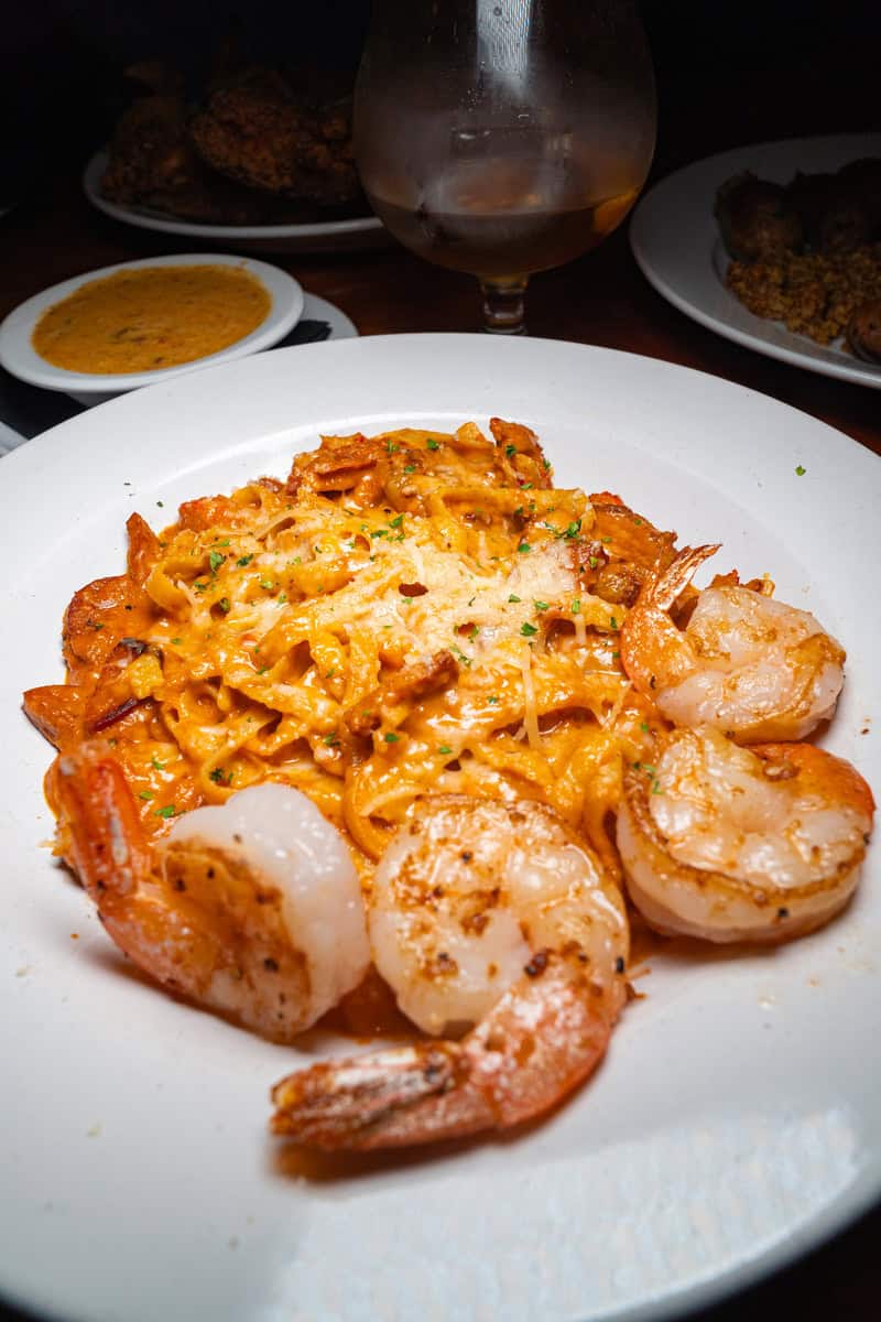a plate of pasta with shrimp and cheese