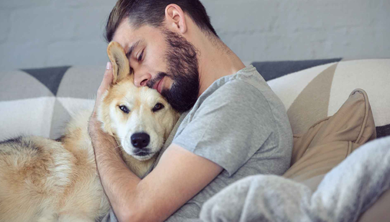 a man hugging a dog