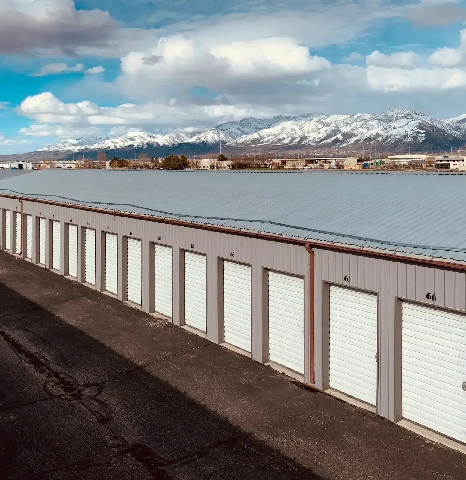 a row of storage units with a snowy mountain in the background