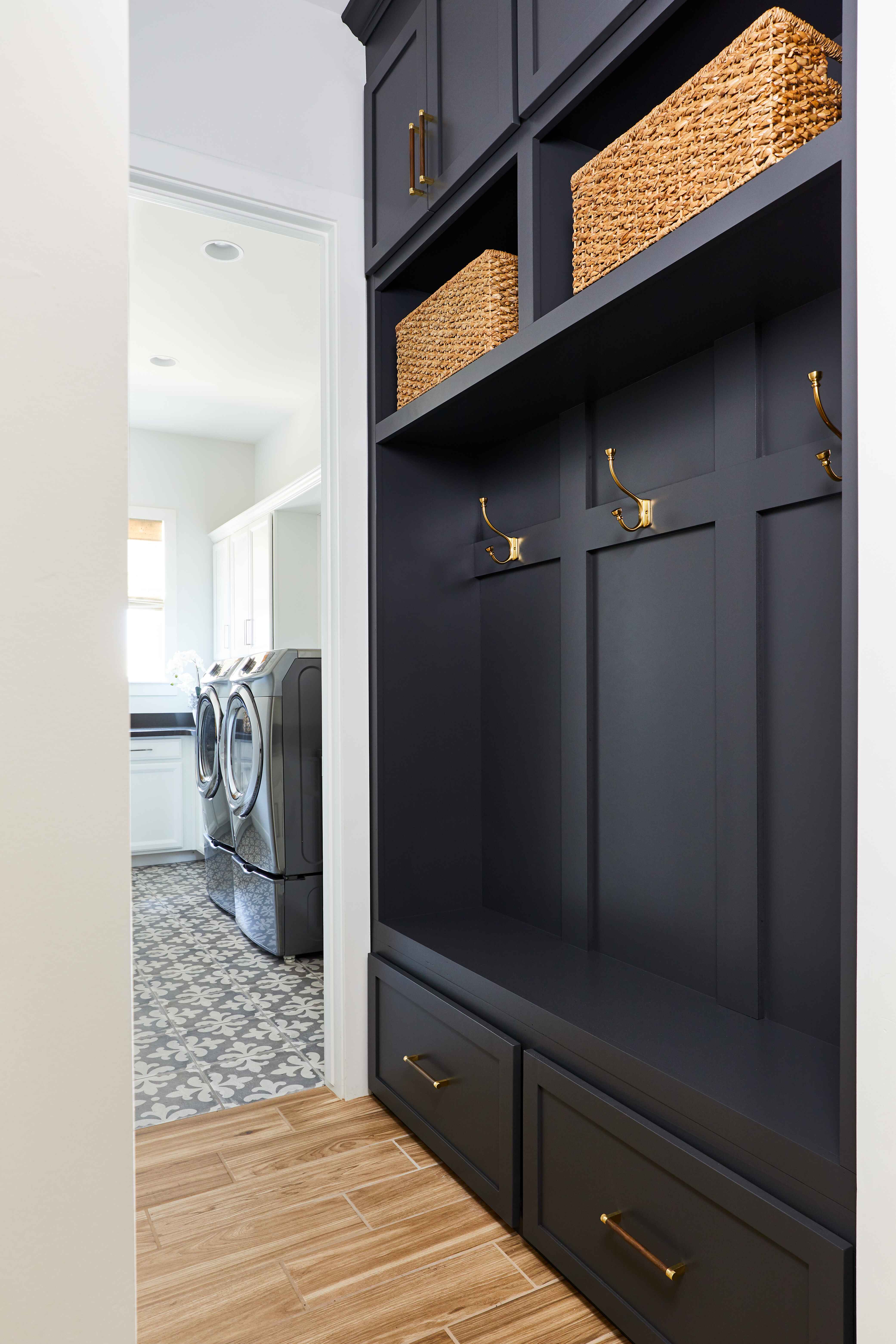 a black shelf with hooks and baskets in a laundry room