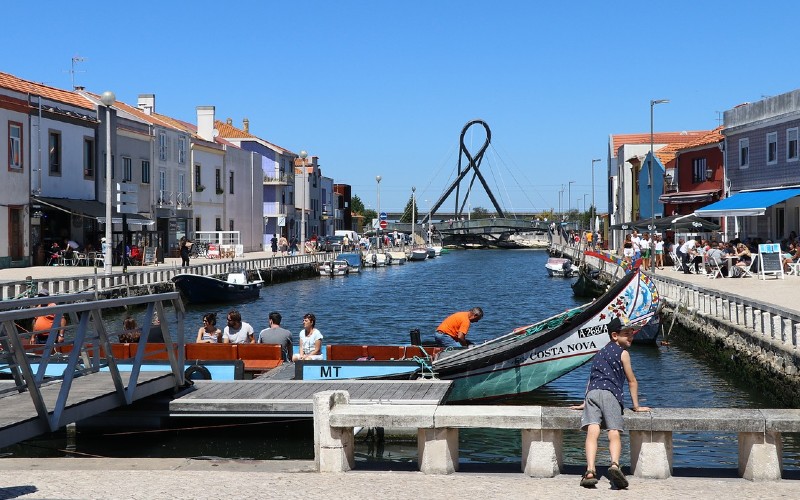 a group of people on a dock next to a canal