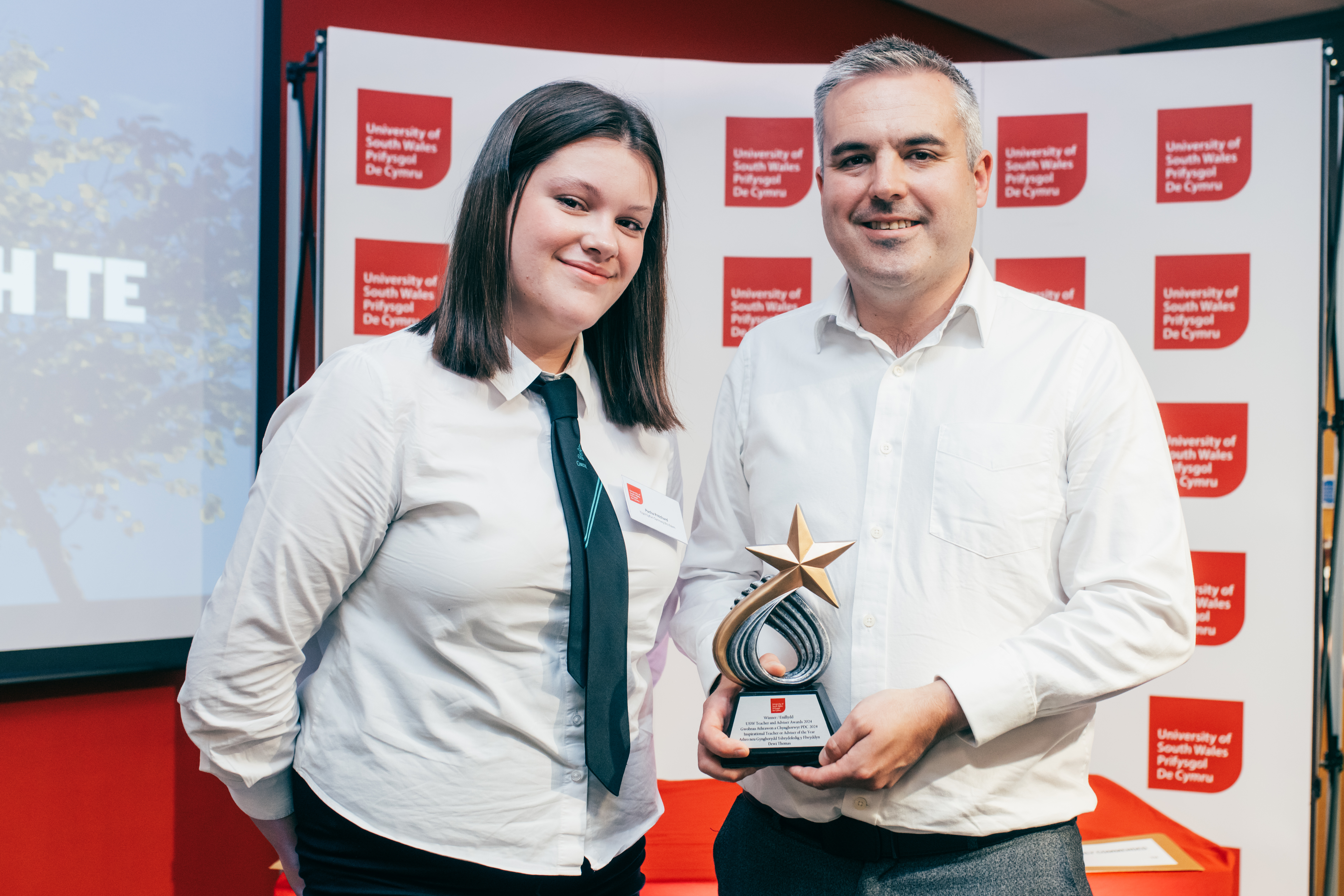 a man and woman holding a trophy