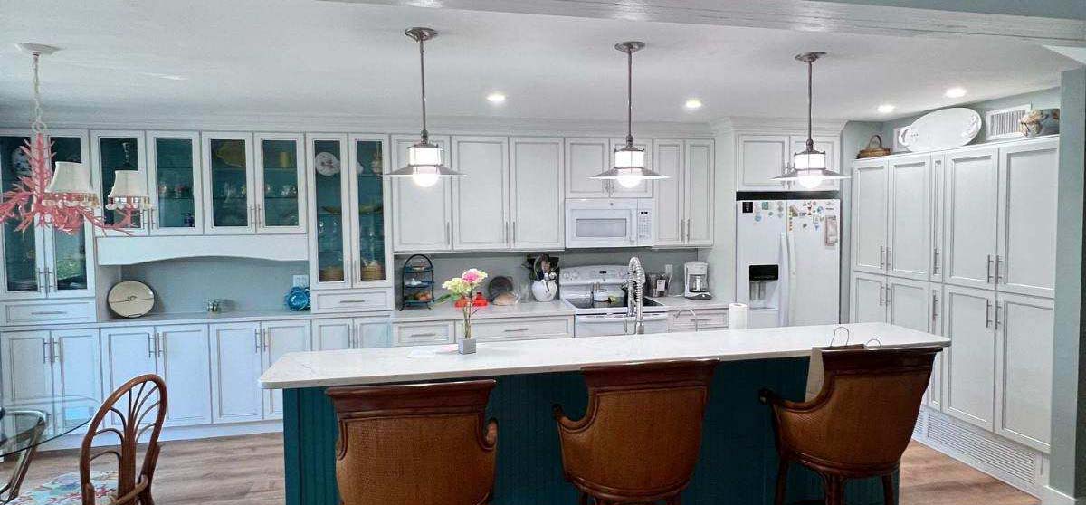 a kitchen with white cabinets and a bar