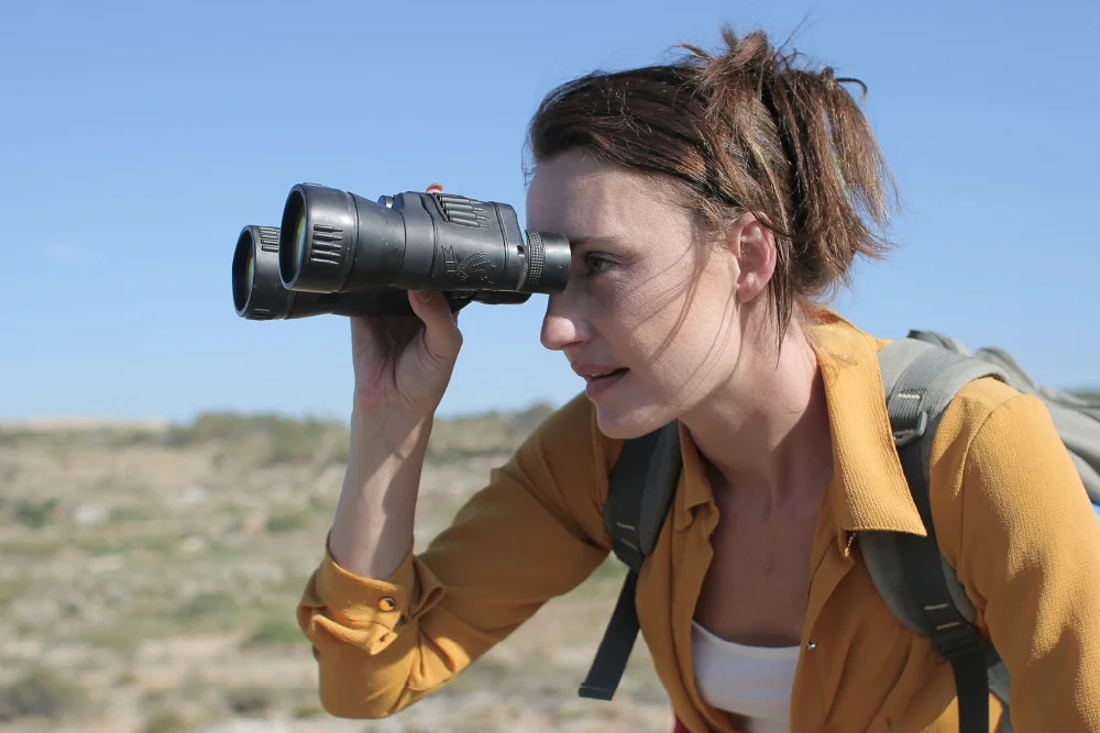 a woman looking through binoculars