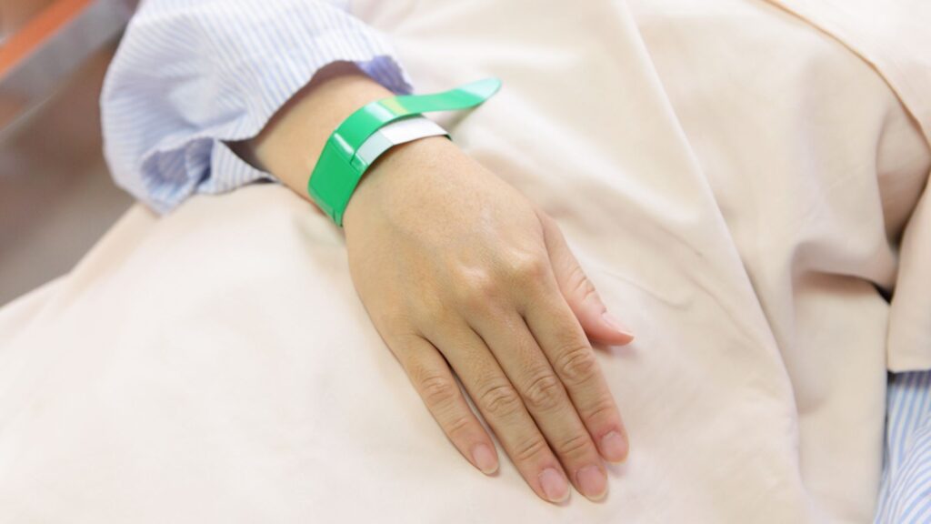 a hand with a green wristband on it