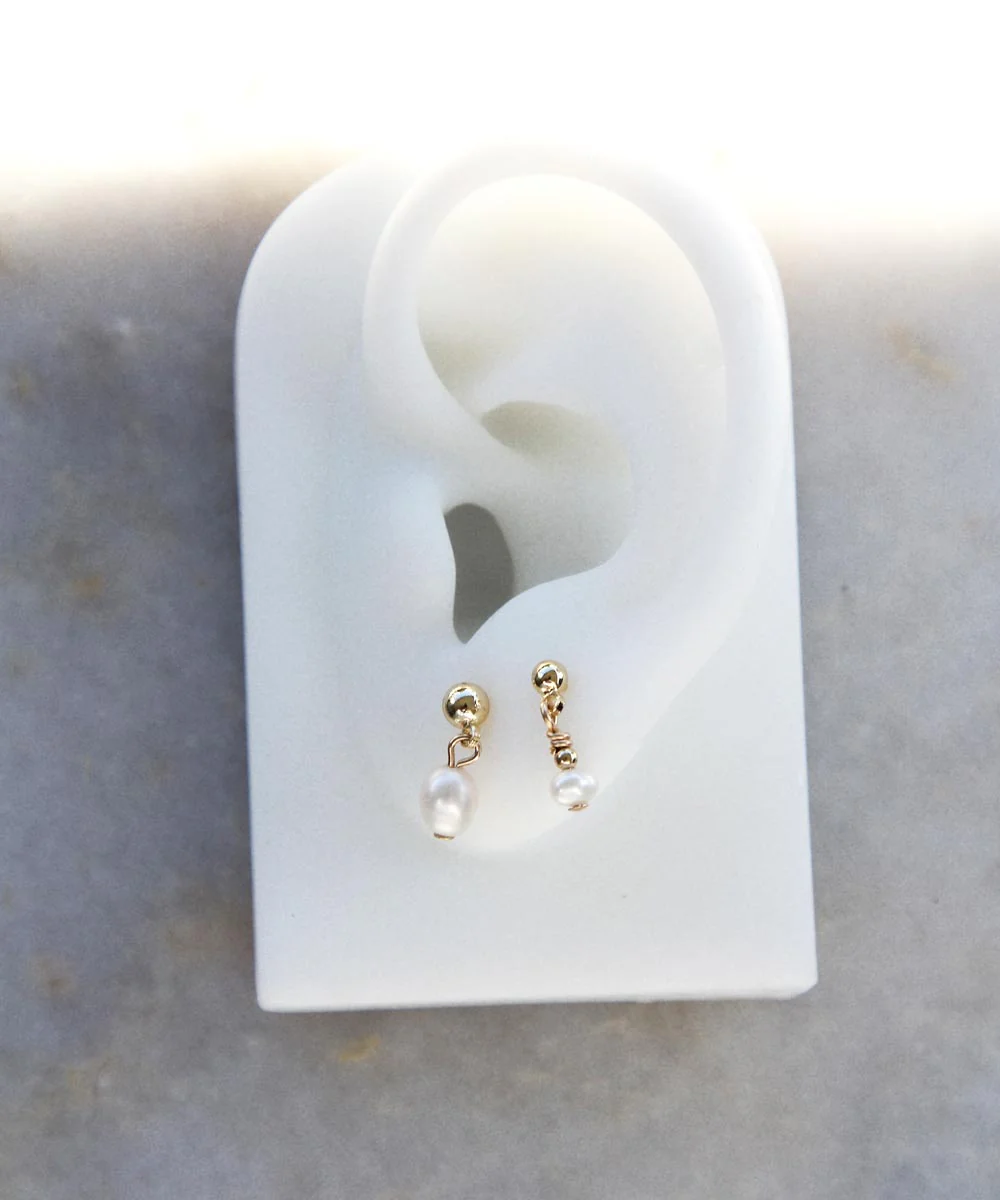 a pair of earrings in a white plastic ear