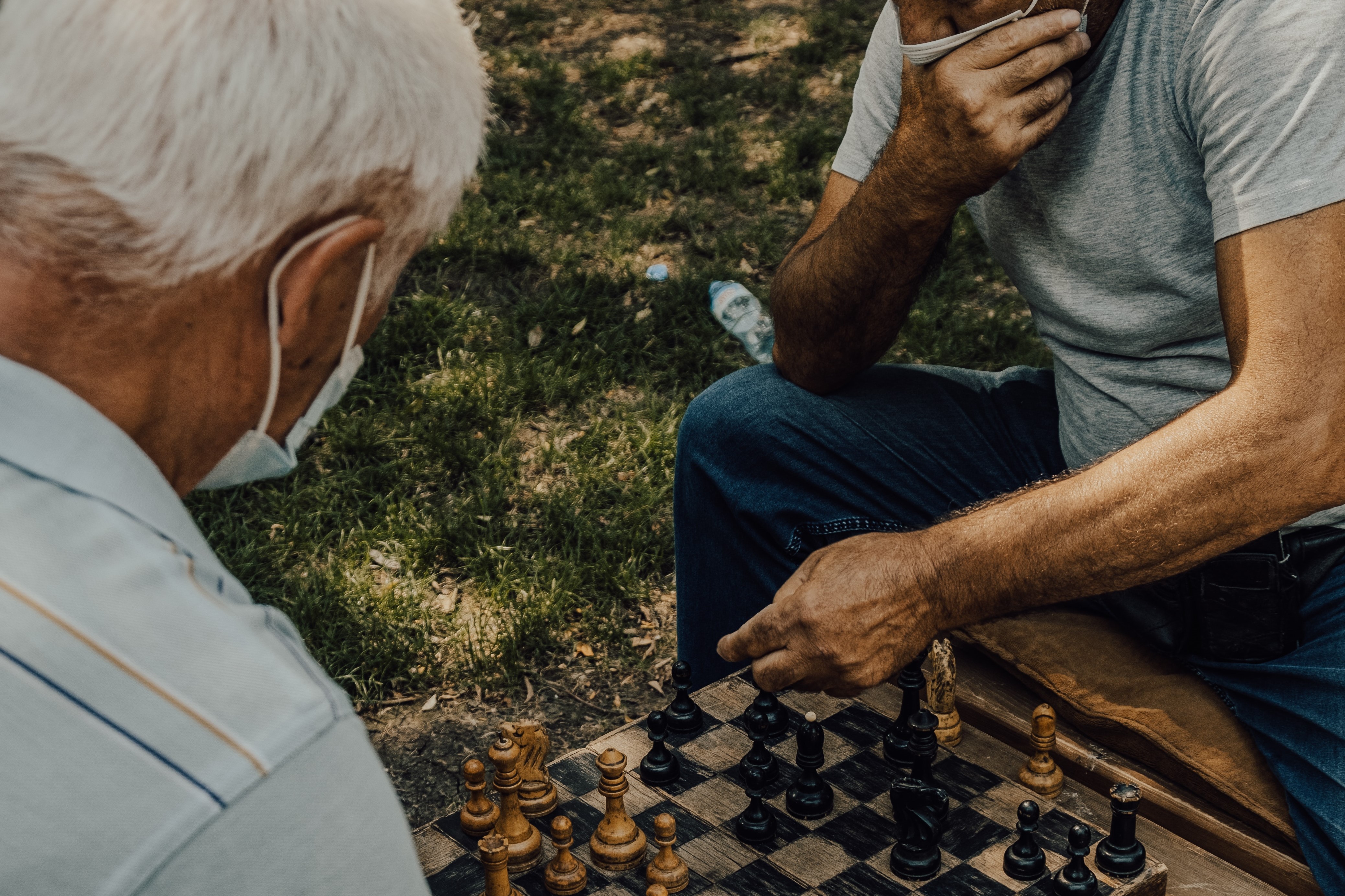 two men playing chess outside