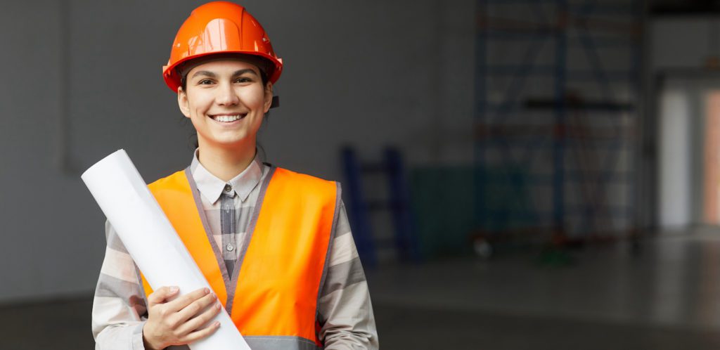 a woman wearing a hard hat and orange vest