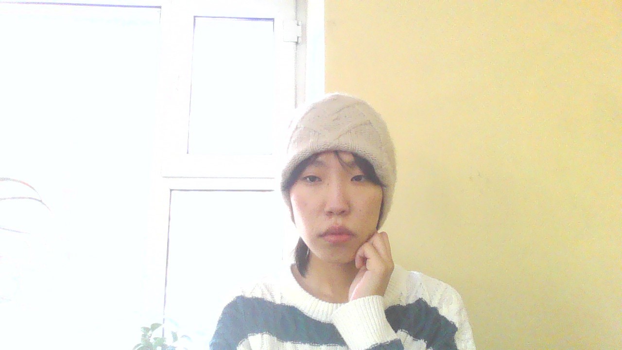 a woman with a knit hat and hand on her chin
