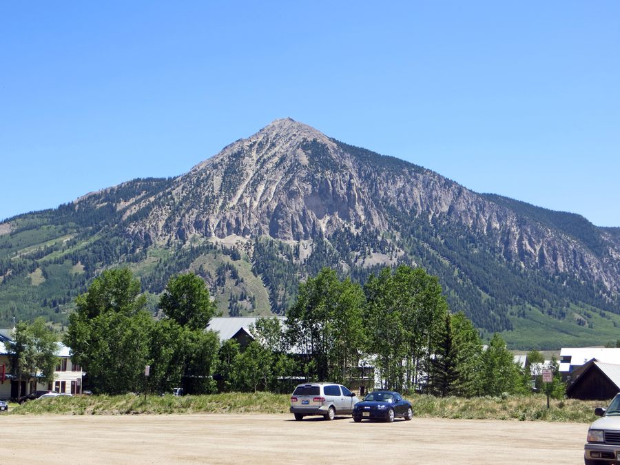 cars parked cars in front of a mountain