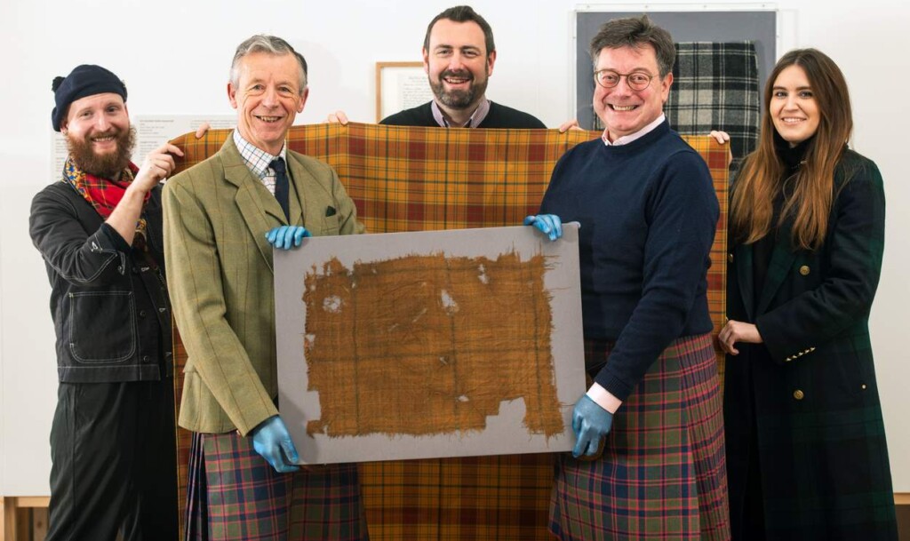 a group of men holding a piece of fabric