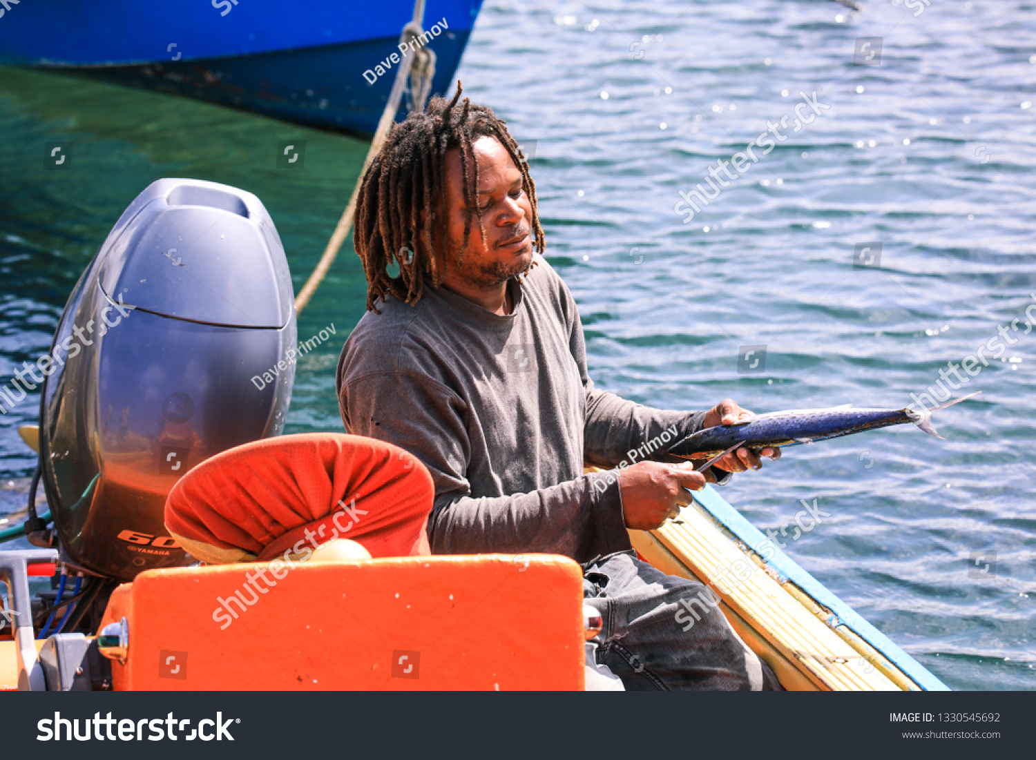 a man sitting in a boat holding a fish