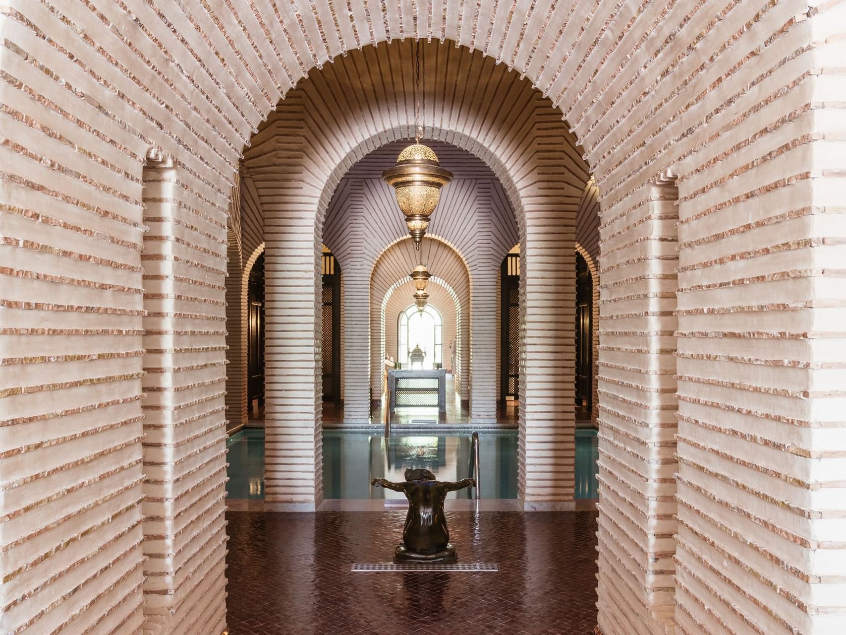 a hallway with arches and a fountain