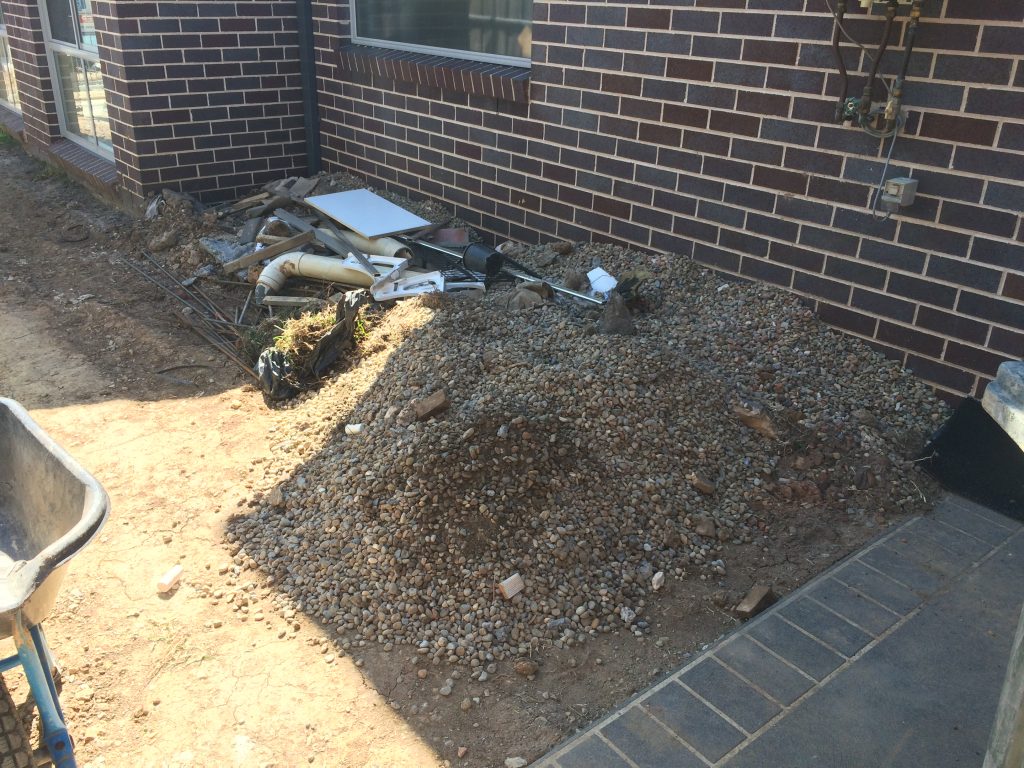 pile of dirt next to a brick building