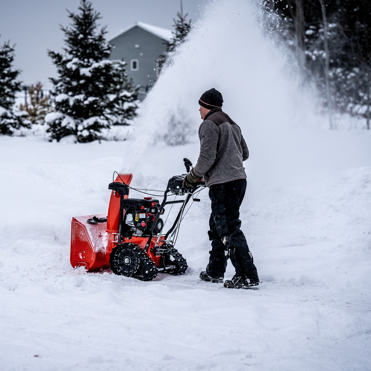 a man using a snow blower in the snow