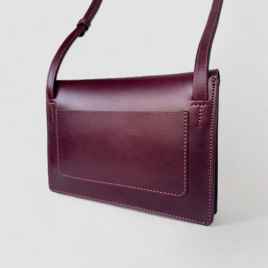 a purple leather purse with a strap