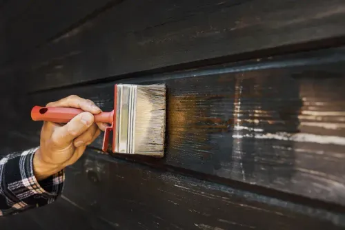 a person painting a wood wall