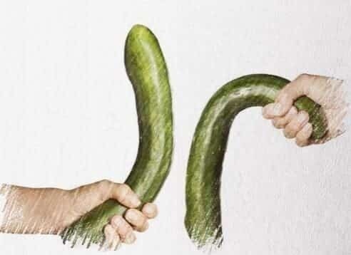 a cucumber being held by a hand