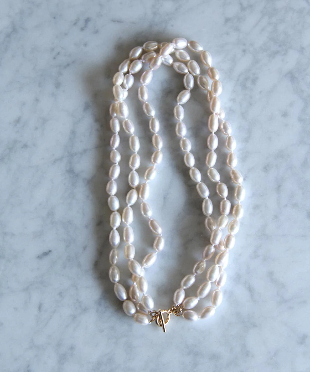 a necklace of pearls on a marble surface