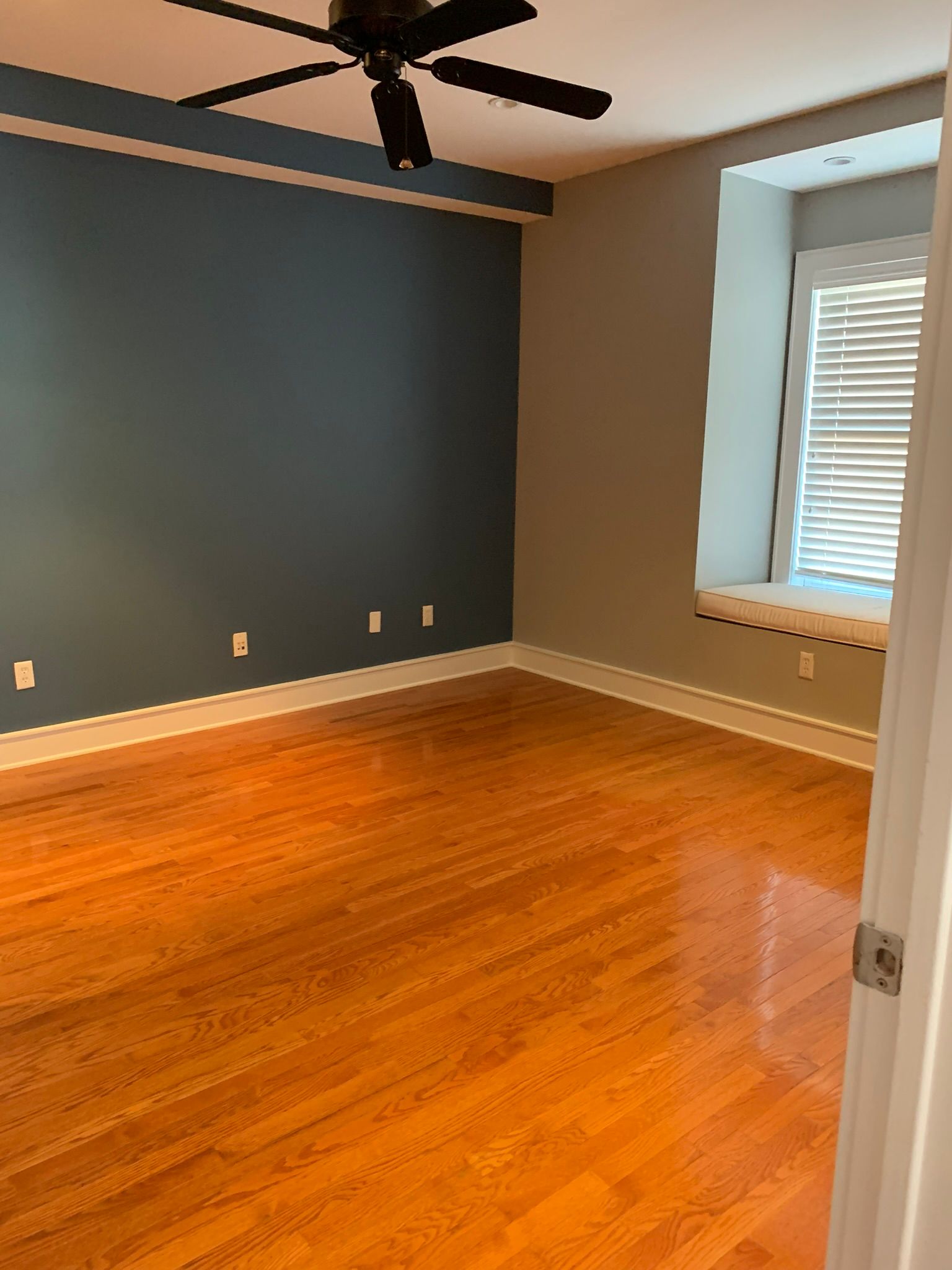 a room with a wood floor and a window