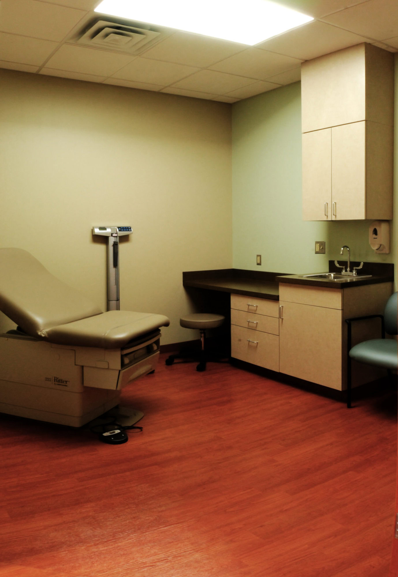 a medical room with a chair and a sink