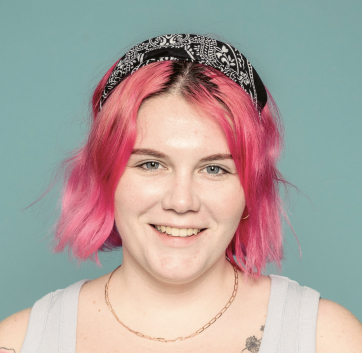 a woman with pink hair and a bandana