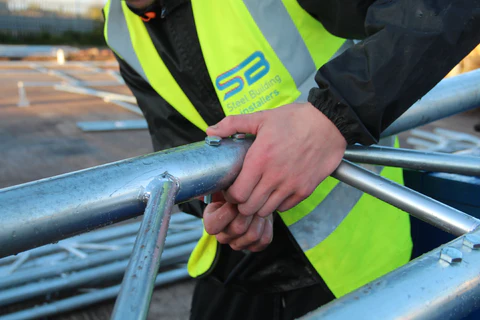 a man in a reflective vest holding a metal bar