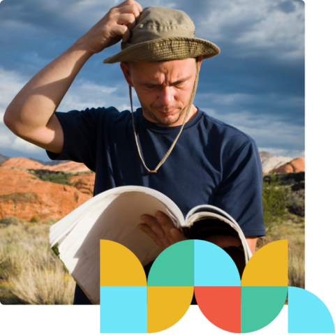 a man reading a book in a desert