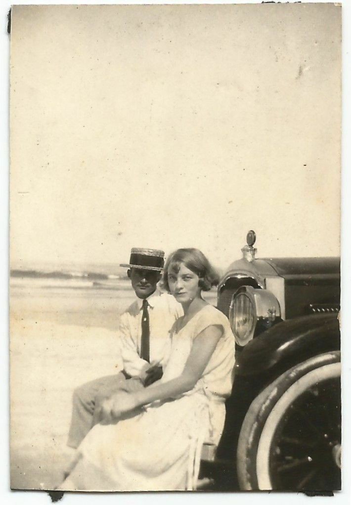 a man and woman sitting on a car