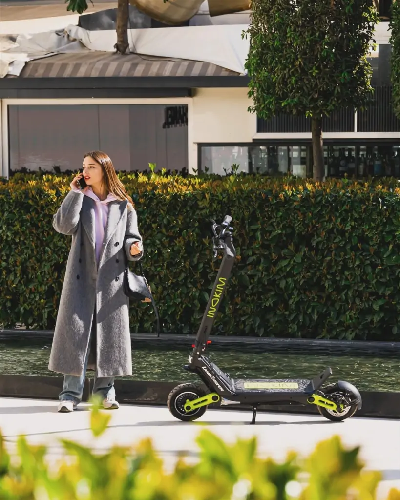 a woman standing next to a scooter