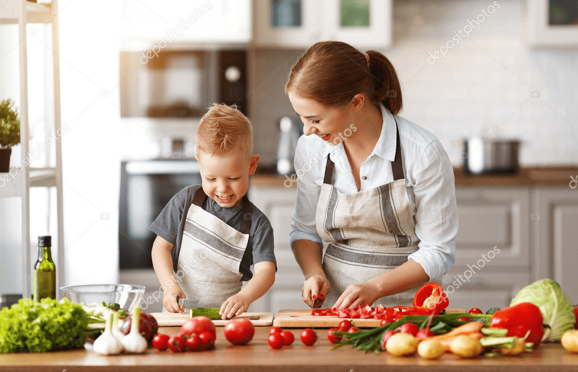 a woman and child cutting vegetables