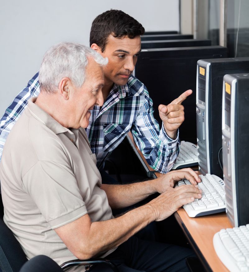 a man pointing at a man's hand on a computer