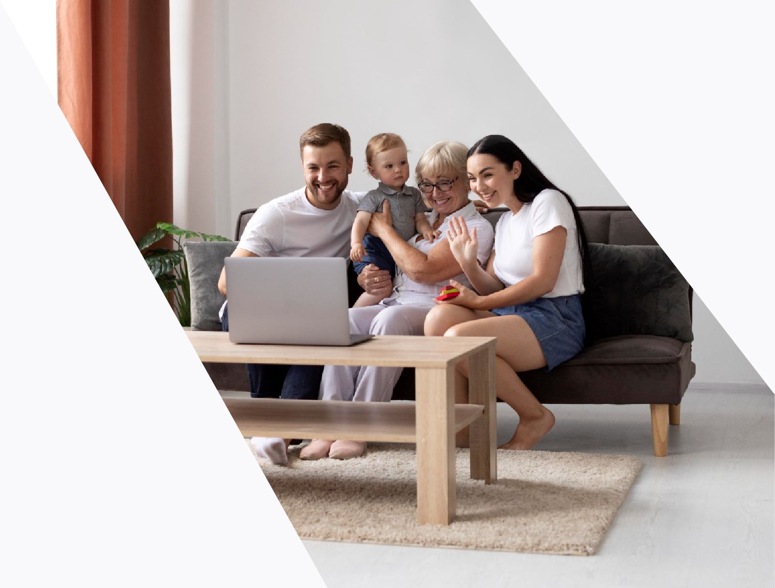 a family sitting on a couch with a laptop