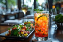 a glass of liquid with a straw next to a plate of food