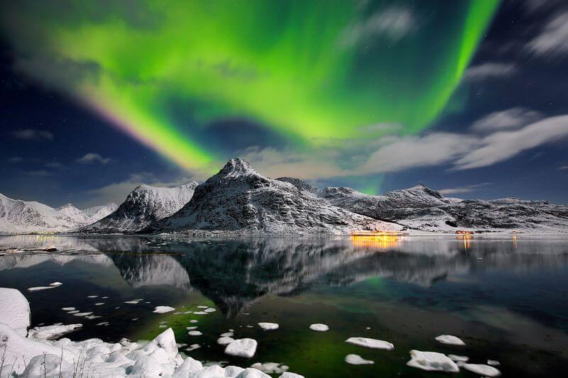 a green lights in the sky over a body of water