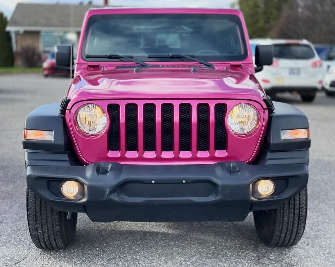 a pink jeep parked in a parking lot