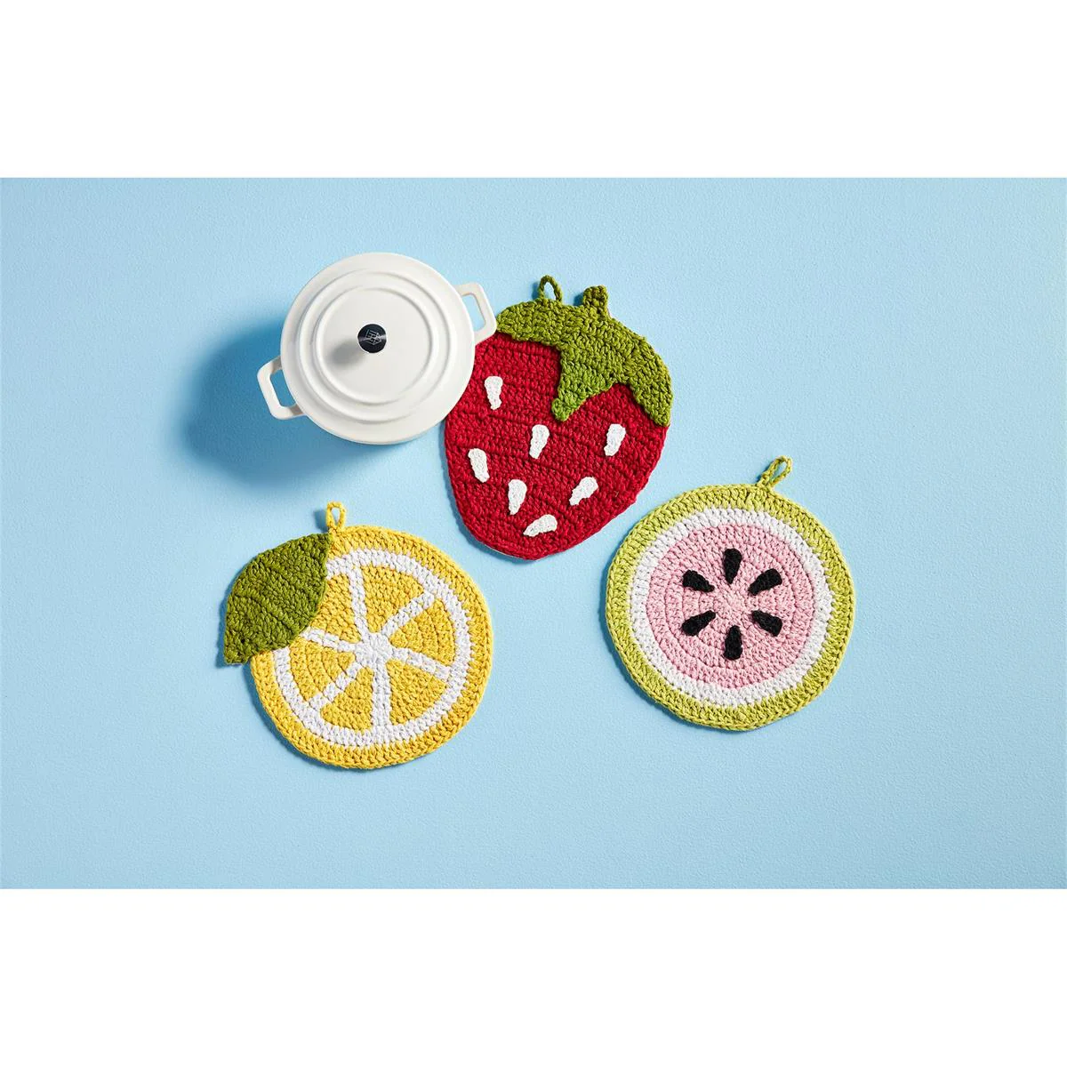 a group of knitted fruit coasters