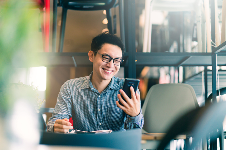 a man smiling at a cellphone