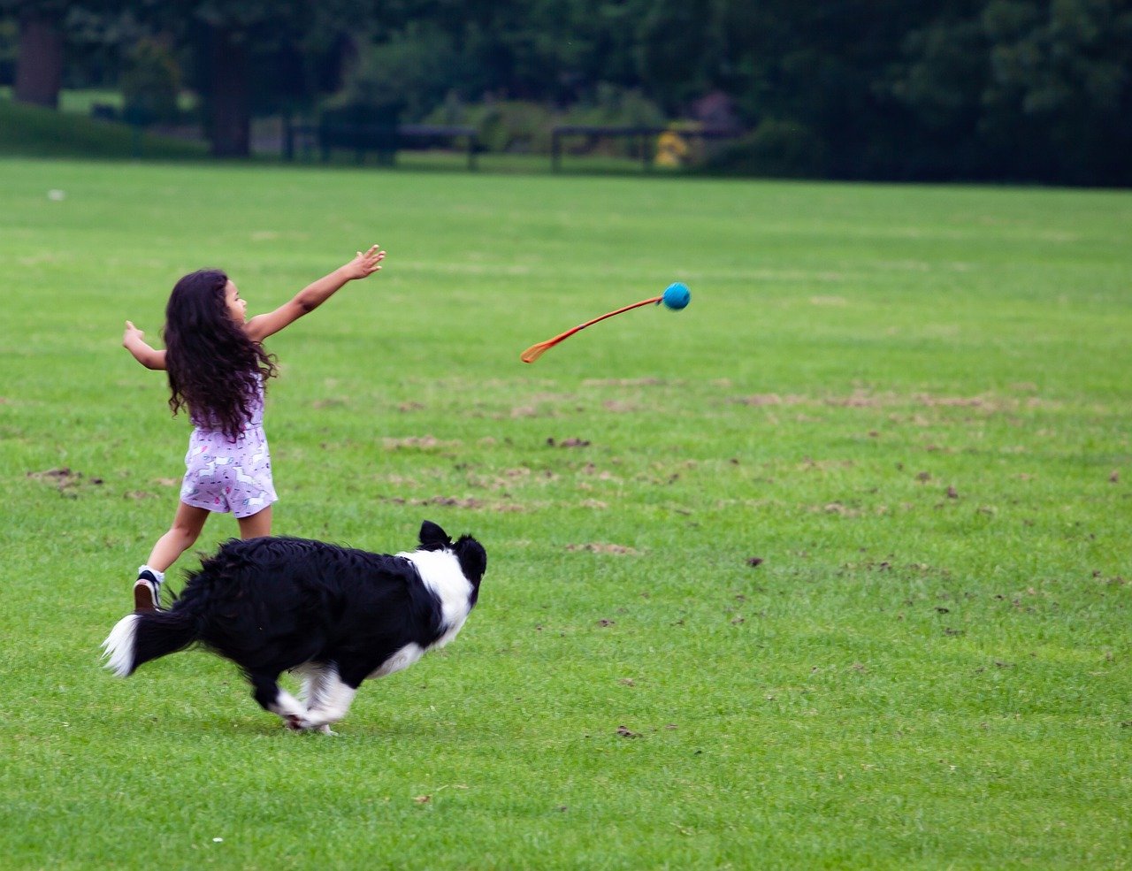 a girl chasing a ball with a stick