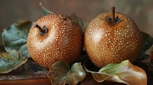 two brown apples with leaves