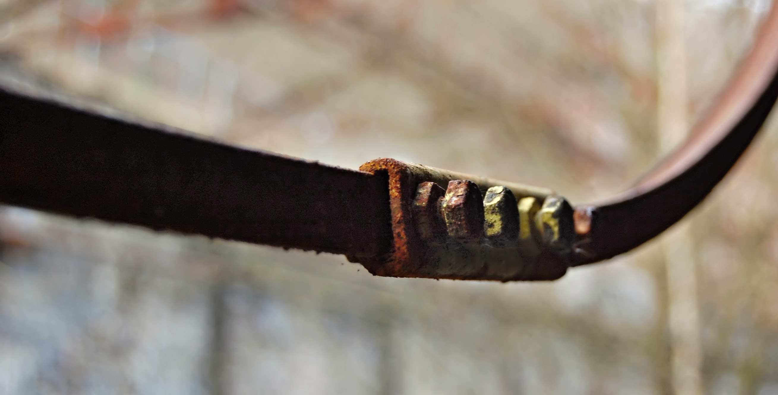 a rusty metal bar with many bolts