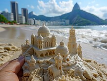 a hand holding a sand castle