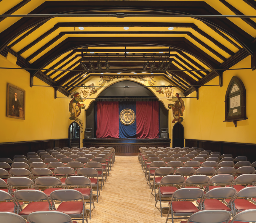 a room with rows of chairs and a curtain