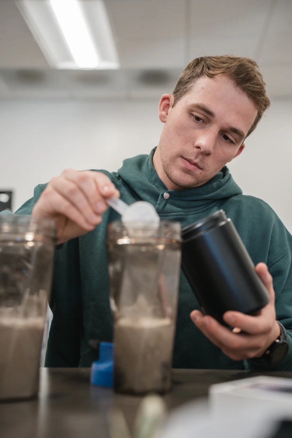 a man pouring a powder into a blender