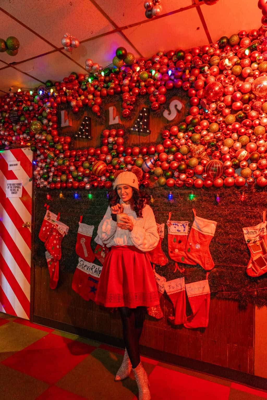 a woman standing in front of a wall of christmas decorations