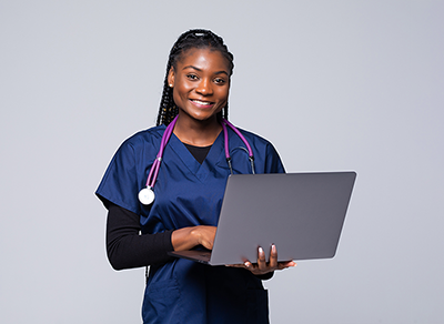 a woman in blue scrubs holding a laptop