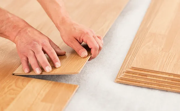 a person's hands placing a piece of wood
