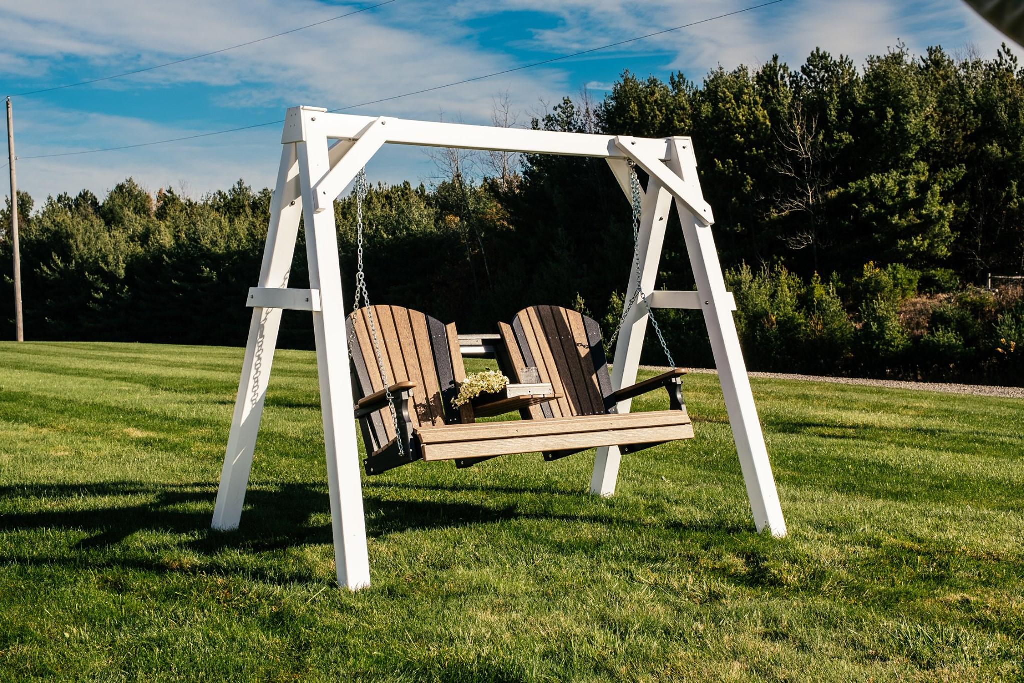 a wooden swing in a grassy field